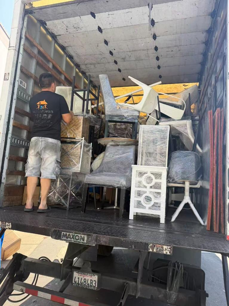 A crew member loading wrapped furniture out of a Hello Movers truck